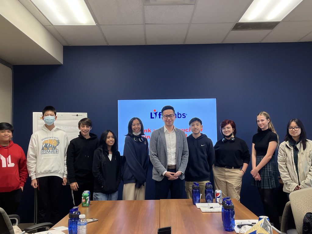 A group of students in B.C. gather in a boardroom with a LifeLabs team member to talk about the medical laboratory industry for Take Our Kids to Work Day